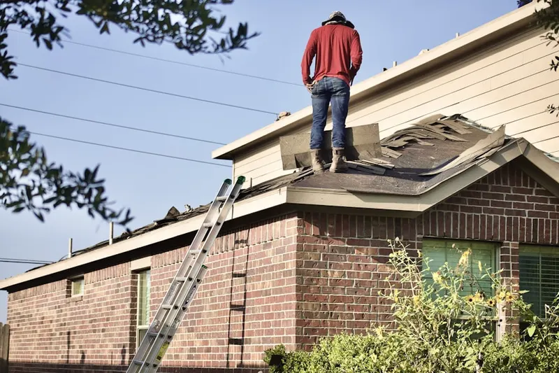 Professional roofer working on a residential roof in Welches